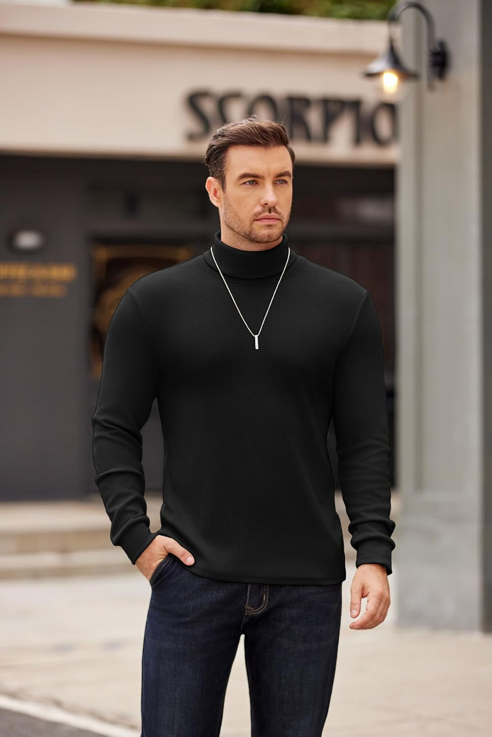 Hombre con el cuello alto Reignardo y collar plateado, presencia elegante en la ciudad